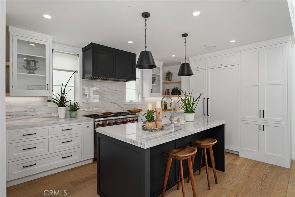 Quartz countertops and backsplash with view of kitchen storage and refrigerator. Counter bartop seating - 418 1/2 Larkspur, Newport Beach CA 92625 - photo 12
