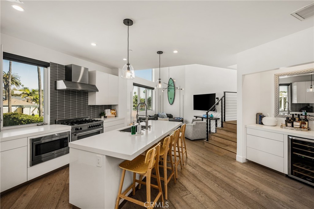 The chef’s kitchen is appointed with quartz countertops, a generous center island, modern European-style cabinetry, and - 4405 Channel Place, Newport Beach CA 92663 - photo 17