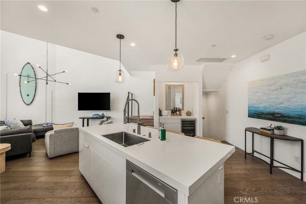 The chef’s kitchen is appointed with quartz countertops, a generous center island, modern European-style cabinetry, and - 4405 Channel Place, Newport Beach CA 92663 - photo 19