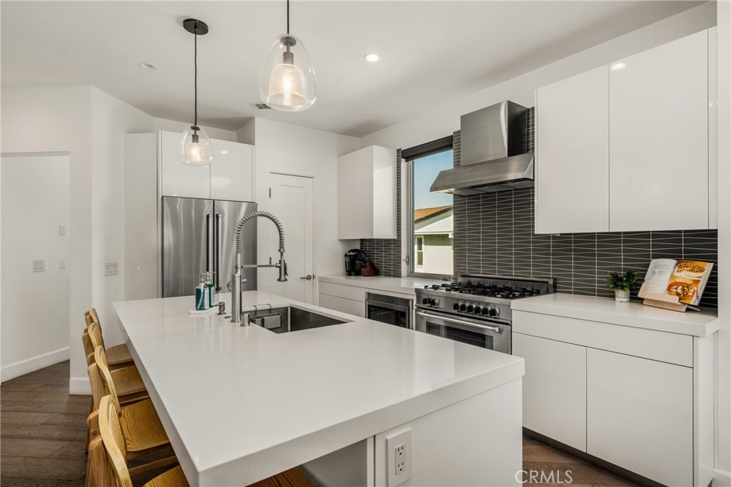 The chef’s kitchen is appointed with quartz countertops, a generous center island, modern European-style cabinetry, and - 4405 Channel Place, Newport Beach CA 92663 - photo 20
