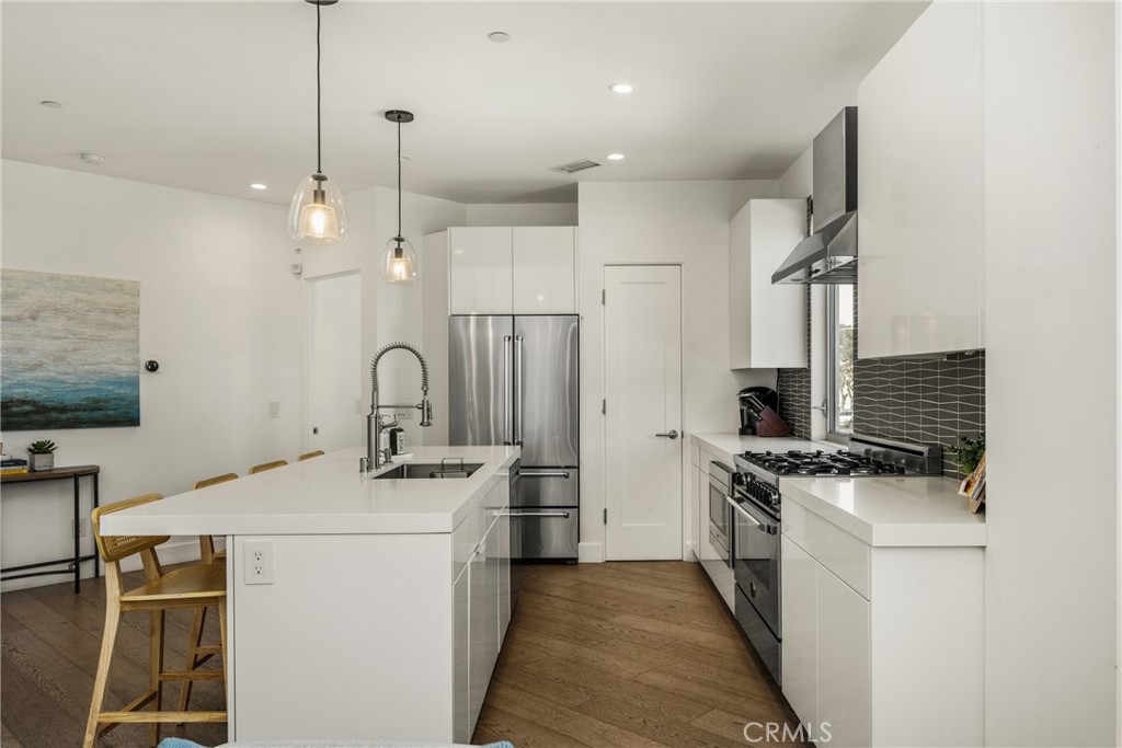The chef’s kitchen is appointed with quartz countertops, a generous center island, modern European-style cabinetry, and - 4405 Channel Place, Newport Beach CA 92663 - photo 21