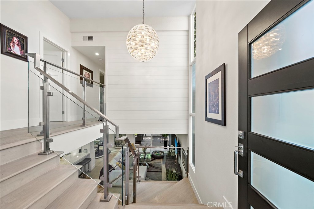 Open the modern front door to see the gorgeous glass & stainless steel staincase, along with the hundreds of glass piece - 526 Vista Grande, Newport Beach CA 92660 - photo 2