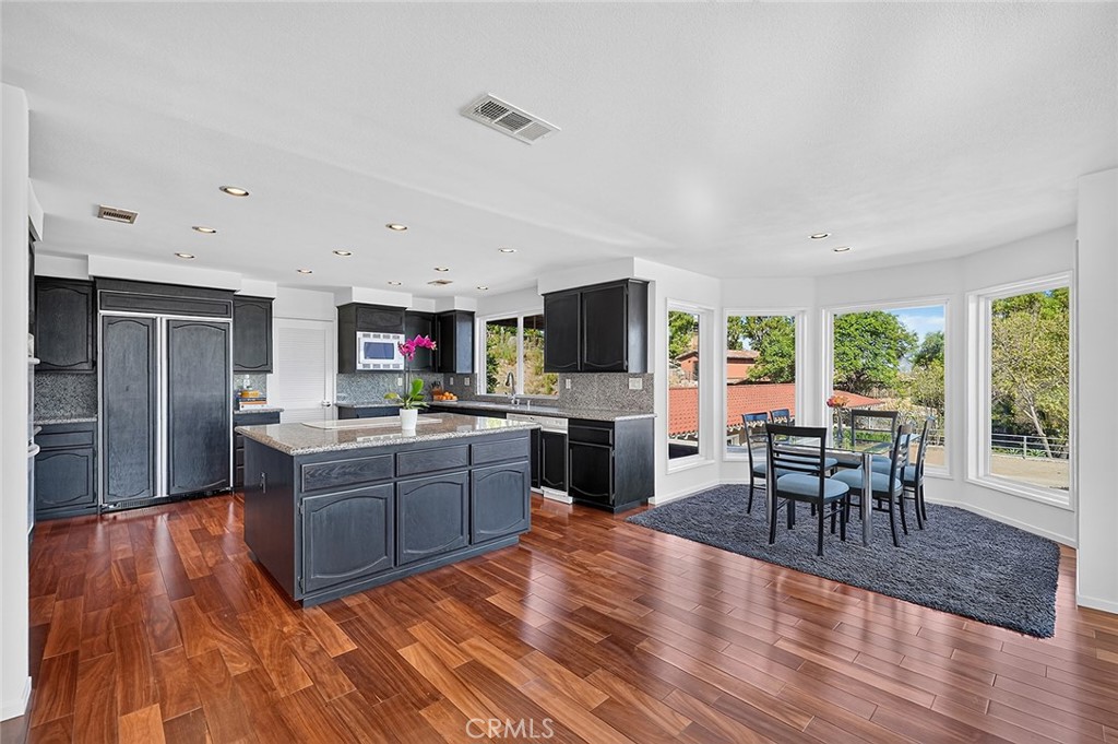 The kitchen has a large island with storage all around and a built in refrigerator - 10571 Morada, Orange CA 92869 - photo 22