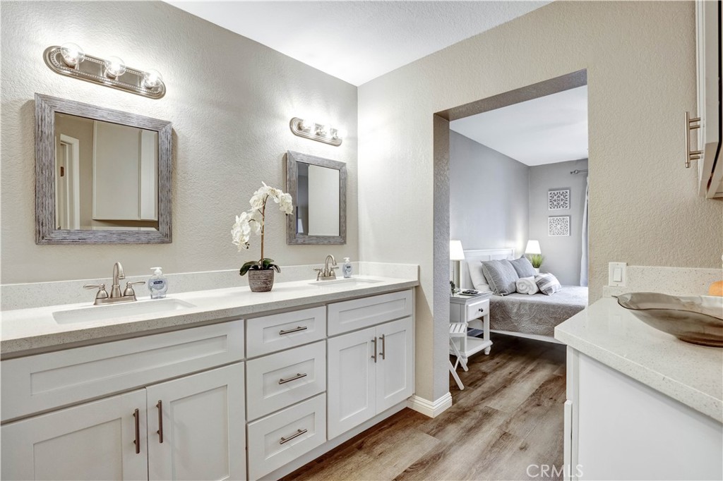 Primary Suite with view to private patio and Smart TV, en suite full Bathroom, vanity area with dual sinks - 129 N Cross Creek, Orange CA 92869 - photo 25