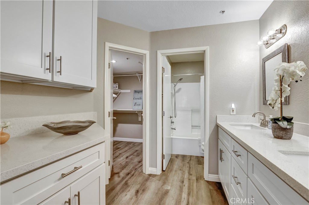 Primary Suite with view to private patio and Smart TV, en suite full Bathroom Vanity Area with dual sinks - 129 N Cross Creek, Orange CA 92869 - photo 26