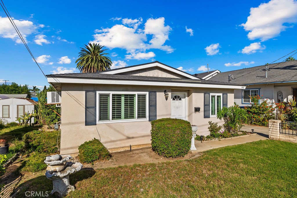 Another look at the home's classic single-story exterior, front lawn, and welcoming entry. - 150 S Park, Orange CA 92869 - photo 2