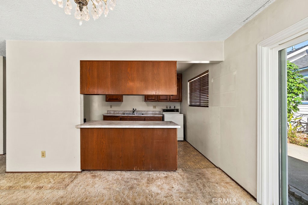 Breakfast counter creates a connection between the kitchen and the spacious living and dining area. - 150 S Park, Orange CA 92869 - photo 13