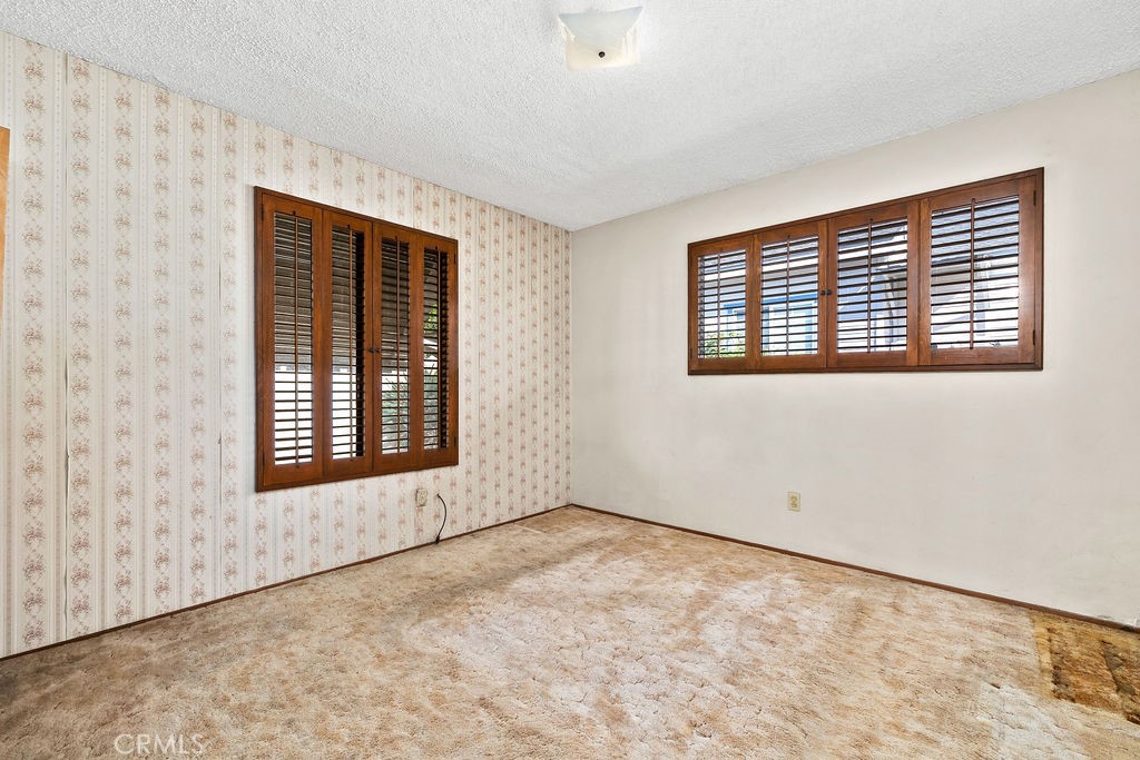 Bedroom with two windows featuring plantation-style shutters and an opportunity to update with your own finishes. - 150 S Park, Orange CA 92869 - photo 20