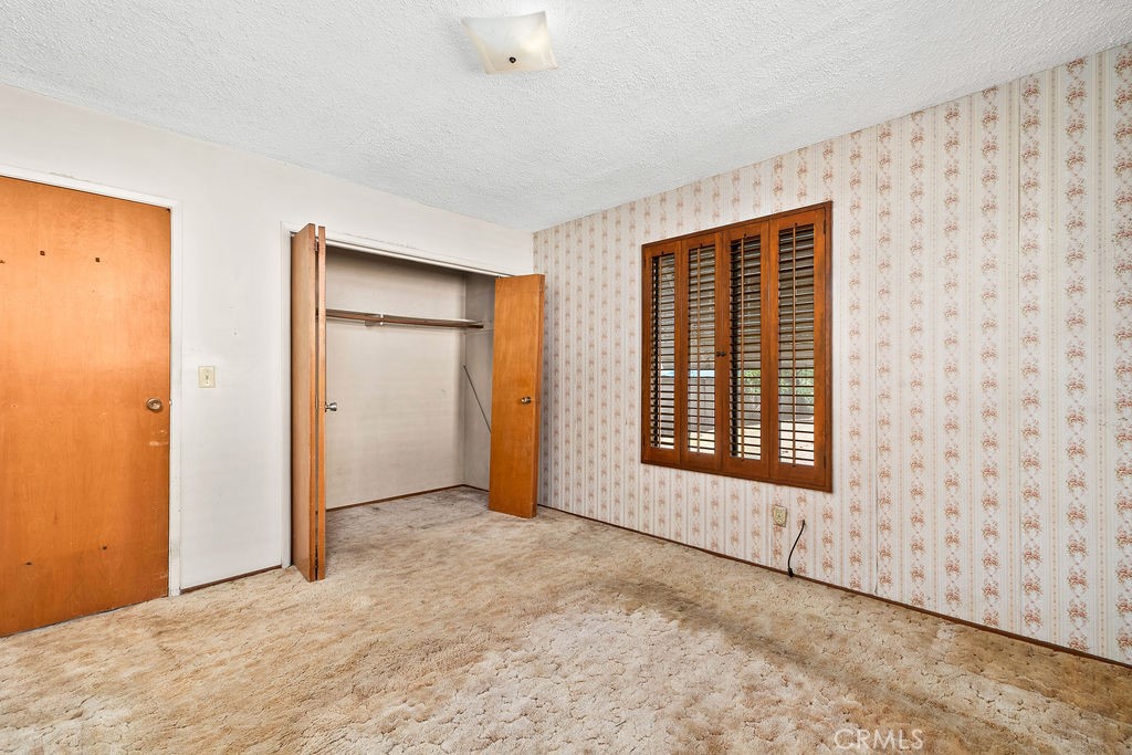 Additional view of the bedroom showing the closet and natural light from the shuttered window. - 150 S Park, Orange CA 92869 - photo 21