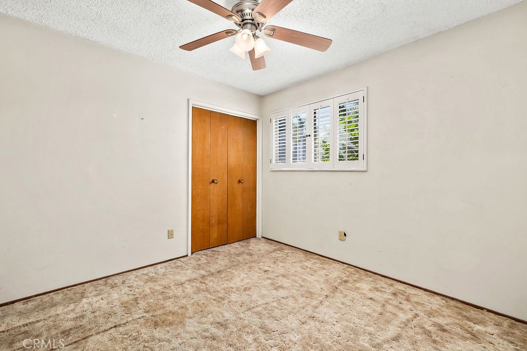Additional bedroom view highlighting the window, ceiling fan, and functional room size. - 150 S Park, Orange CA 92869 - photo 23