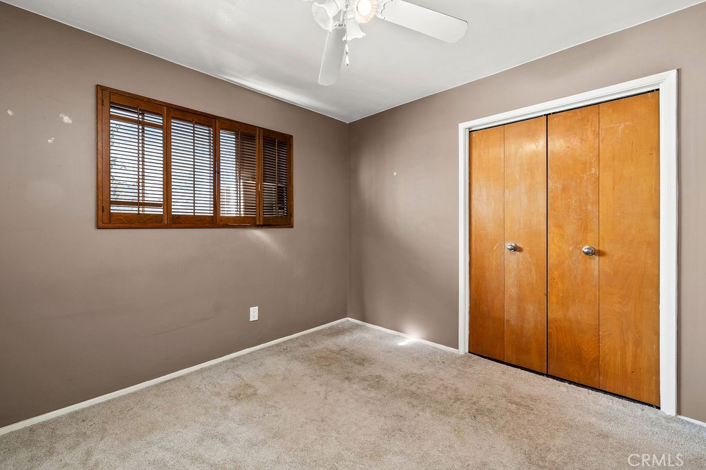 Third bedroom features a ceiling fan, closet, and window with plantation-style shutters. - 150 S Park, Orange CA 92869 - photo 24