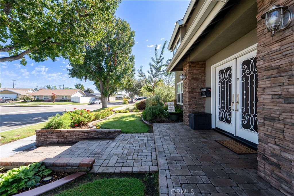 Beautifully professionally landscaped front yard with Stone pavers, mature trees, and custom stacked stone columns. - 390 N Milford Road, Orange CA 92867 - photo 61