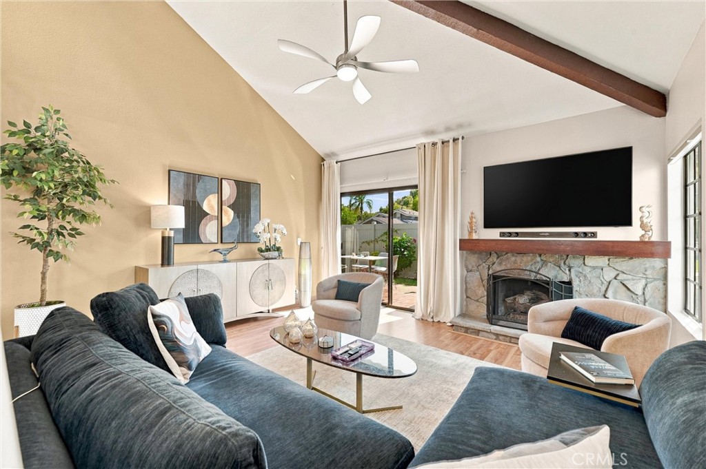 The light-filled living room features a cozy gas fireplace with a custom mantel and recessed dimmable lighting. - 5049 E Almond Avenue 4, Orange CA 92869 - photo 3