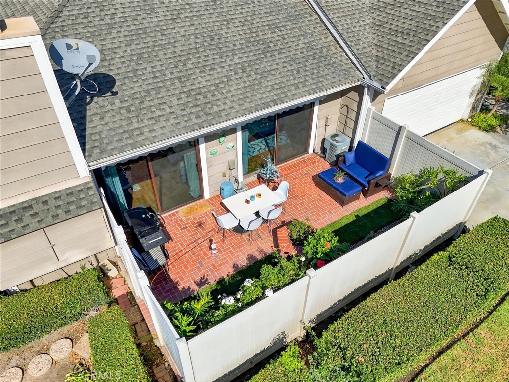 Step outside to your private, landscaped backyard featuring a charming brick patio and an impressive 20' x 10' motorized - 5049 E Almond Avenue 4, Orange CA 92869 - photo 29