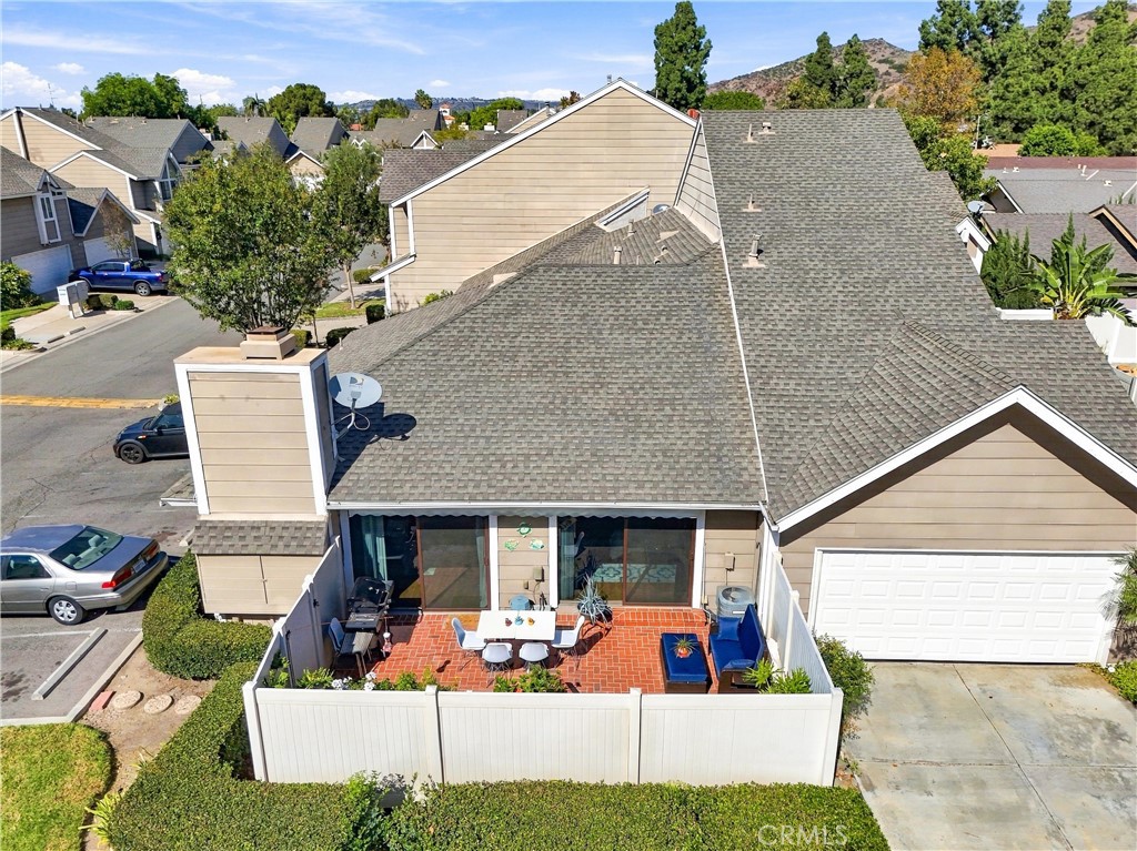 Step outside to your private, landscaped backyard featuring a charming brick patio and an impressive 20' x 10' motorized - 5049 E Almond Avenue 4, Orange CA 92869 - photo 30