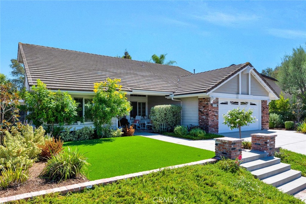 Newer hardscape and driveway with used brick accents and an artificial turf lawn welcome you to 7710 E Strawberry Ridge. - 7710 E Strawberry Ridge, Orange CA 92869 - photo 1