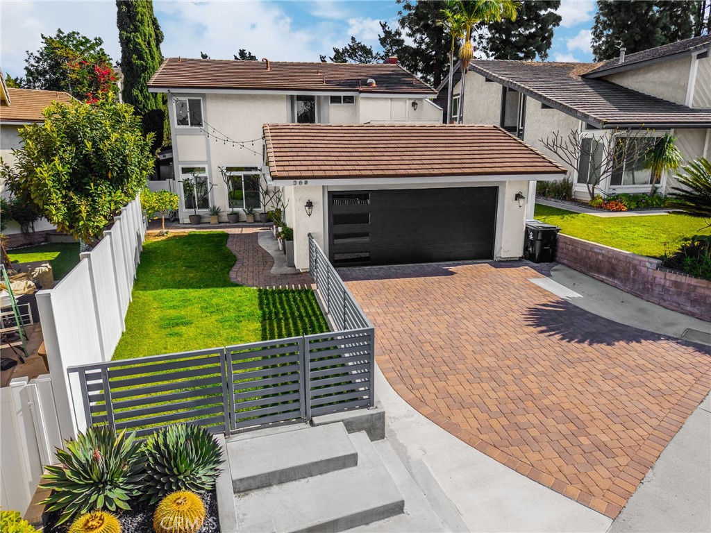 upgraded Exterior welcomes you with a sleek modern garage door, a luxurious brick-paved driveway, and an inviting contem - 180 Horseshoe, Placentia CA 92870 - photo 1