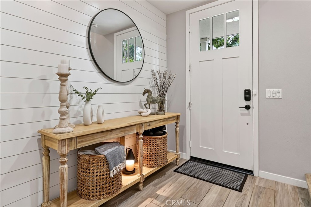 Foyer with shiplap walls and neutral paint. On this level there is a bathroom, full bathroom, & entrance to 2-car garage - 14 Marisol, Rancho Mission Viejo CA 92694 - photo 11