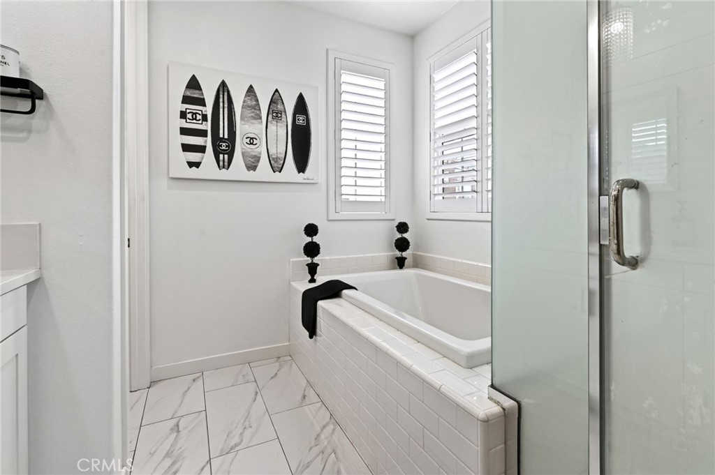 The Primary Bathroom has a large soaking tub and separate shower with frosted privacy doors. - 14 Marisol, Rancho Mission Viejo CA 92694 - photo 36