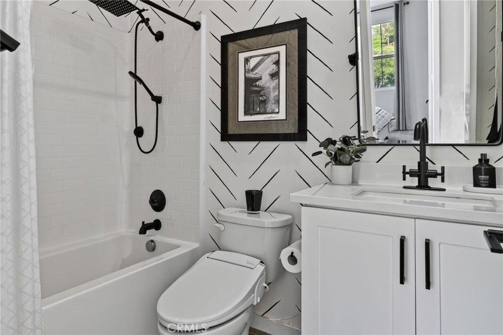 The 4th bedroom sits across the hall from a full bathroom with a tub with a dual shower head. The wallpaper is gorgeous - 14 Marisol, Rancho Mission Viejo CA 92694 - photo 39
