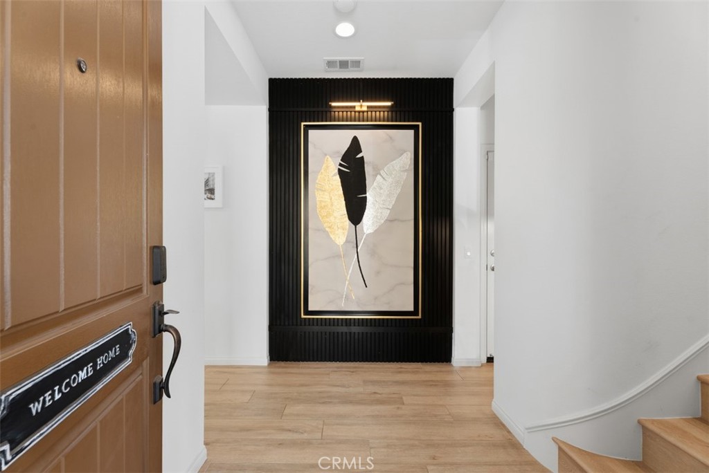 An impressive custom architectural slat feature wall welcomes you inside, creating a striking first impression that sets - 33 Lomada Street, Rancho Mission Viejo CA 92694 - photo 5