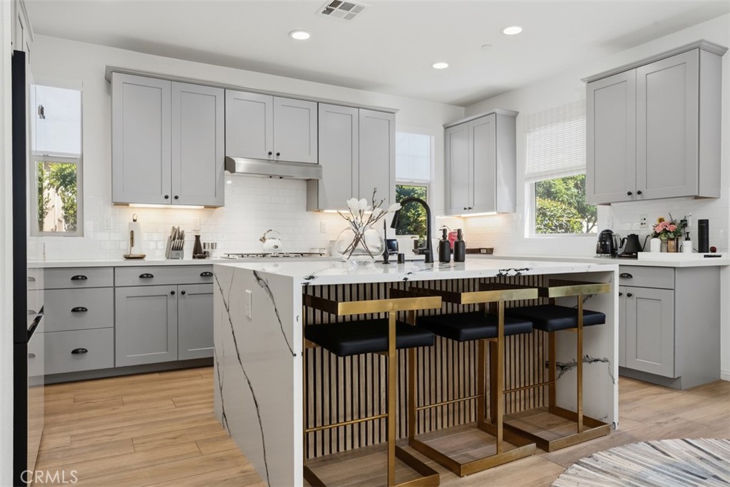 Designed to impress, the completely transformed kitchen is anchored by a stunning waterfall-edge marble island with a cu - 33 Lomada Street, Rancho Mission Viejo CA 92694 - photo 6