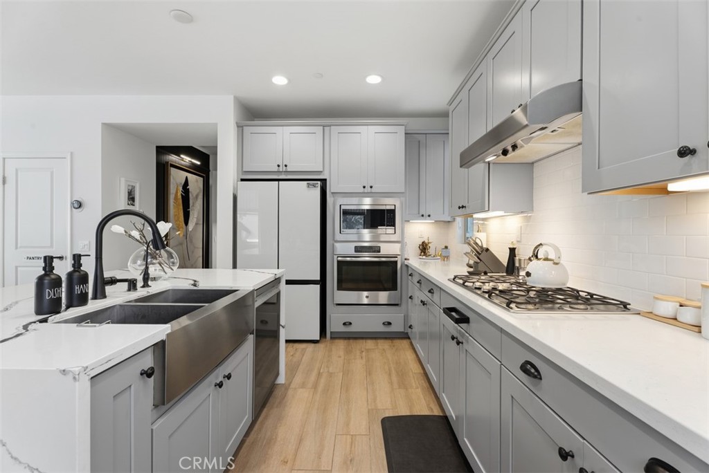 Quartz countertops surround the perimeter, while abundant cabinetry, stainless steel appliances, and expansive work surf - 33 Lomada Street, Rancho Mission Viejo CA 92694 - photo 8
