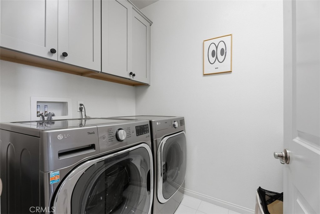 Convenient upstairs laundry room with an utility sink and built-in cabinetry keeps everyday chores organized and close t - 33 Lomada Street, Rancho Mission Viejo CA 92694 - photo 19