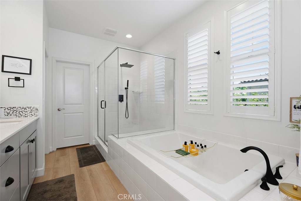 The spa-inspired primary bath showcases a new glass shower enclosure, matte black fixtures, a luxurious rain shower head - 33 Lomada Street, Rancho Mission Viejo CA 92694 - photo 24