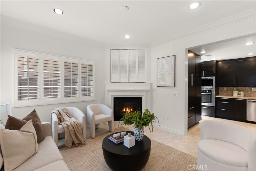 Spacious living area centered around a gas fireplace with elegant mantel, complemented by abundant natural light and an - 15 Poppyfield, Rancho Santa Margarita CA 92688 - photo 5