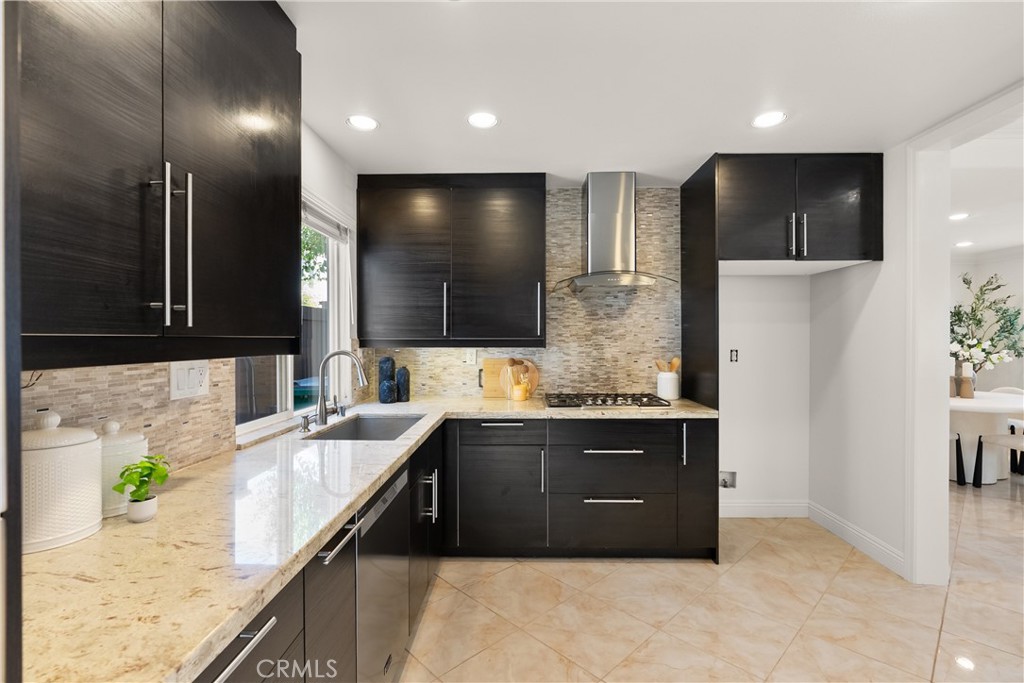 The thoughtfully designed kitchen blends modern finishes with everyday functionality, highlighted by rich cabinetry, gra - 15 Poppyfield, Rancho Santa Margarita CA 92688 - photo 10