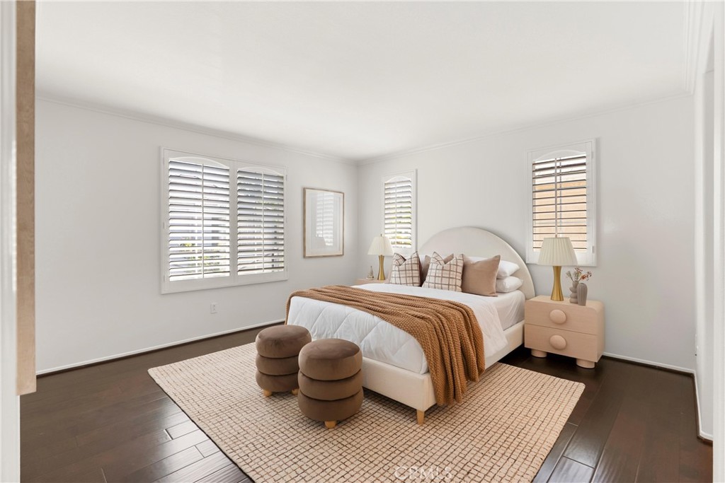 The spacious primary suite offers a peaceful retreat with oversized windows, abundant natural light, rich wood flooring, - 15 Poppyfield, Rancho Santa Margarita CA 92688 - photo 17