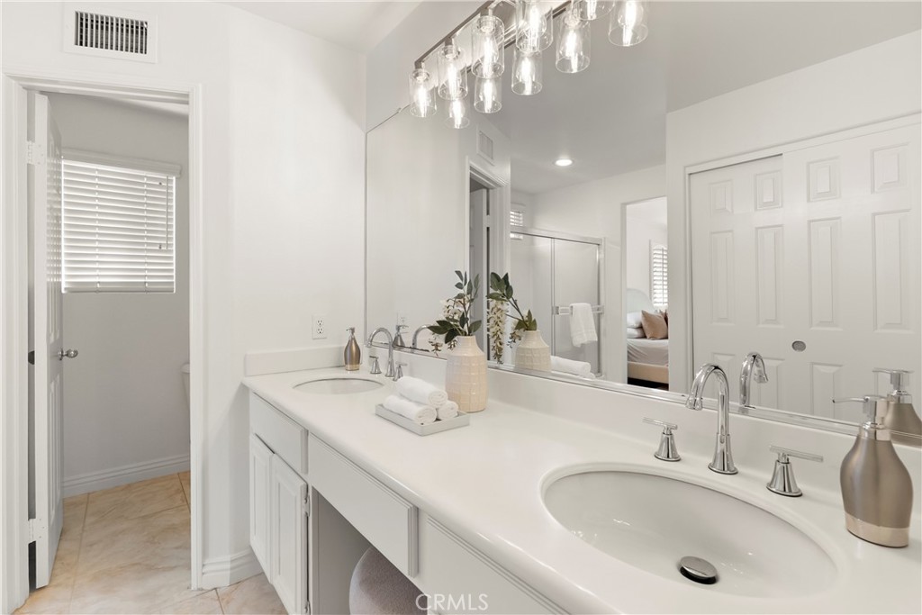 A generous dual vanity provides plenty of space for morning routines, complemented by ample cabinetry, a dedicated seate - 15 Poppyfield, Rancho Santa Margarita CA 92688 - photo 21