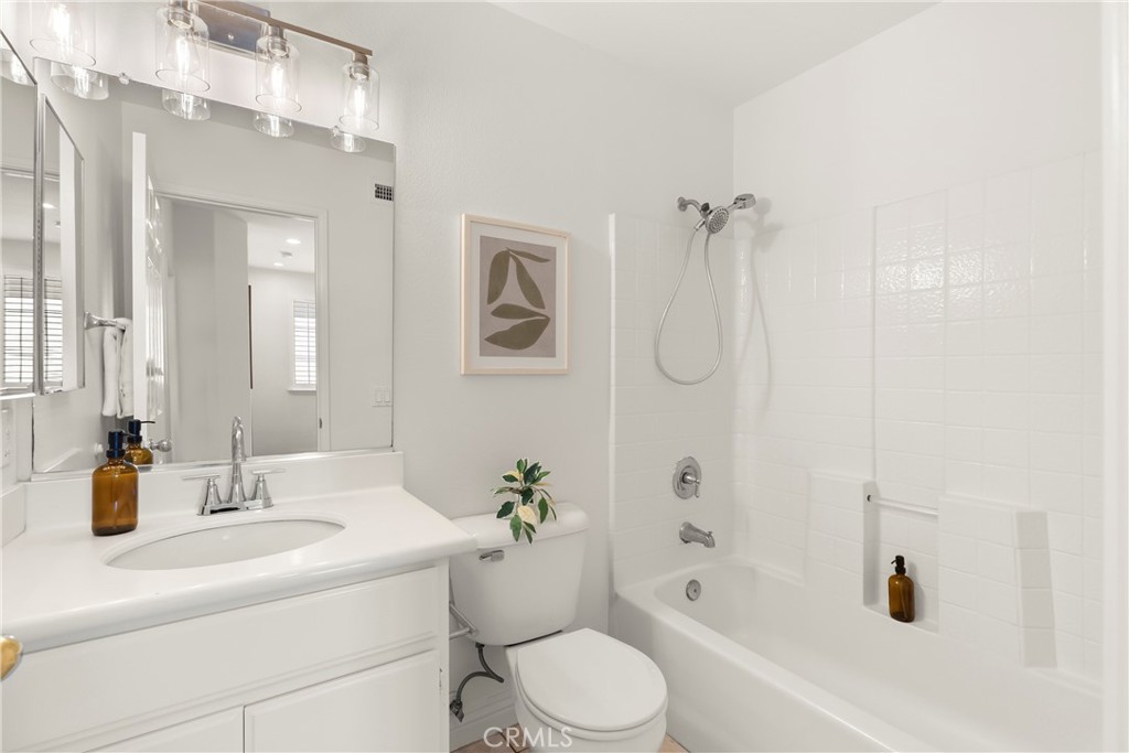 The secondary bathroom features a clean, bright design with a single sink vanity and a shower and tub combination, provi - 15 Poppyfield, Rancho Santa Margarita CA 92688 - photo 24