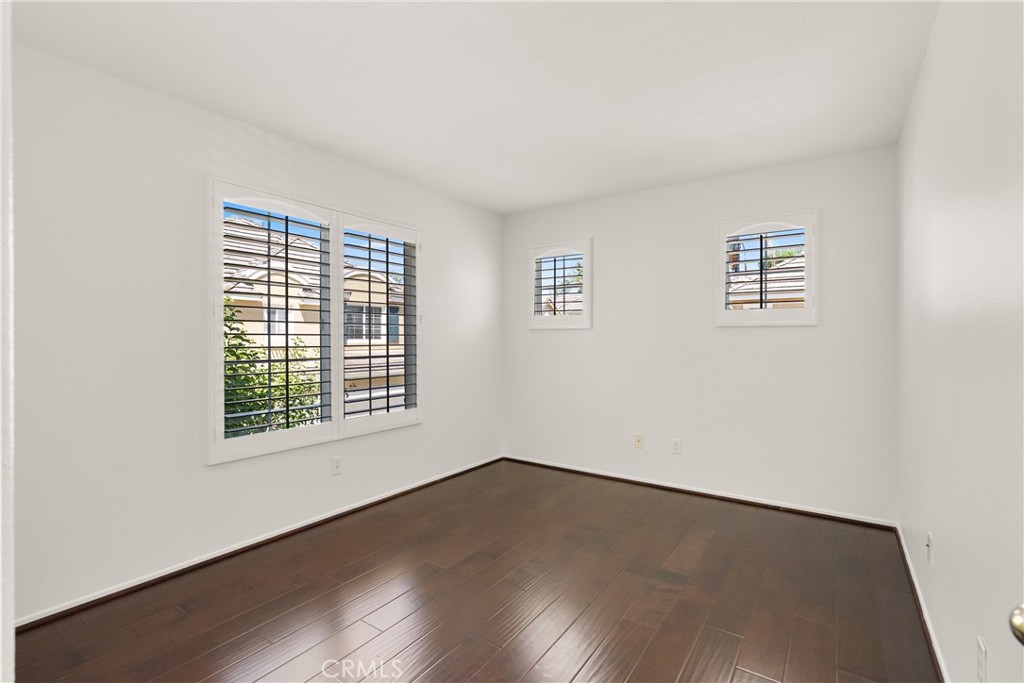 Bright and versatile, this generously sized bedroom features rich wood flooring, plantation shutters, and plenty of spac - 15 Poppyfield, Rancho Santa Margarita CA 92688 - photo 26