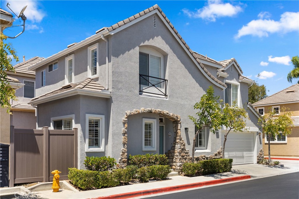 Corner perspective highlighting the home's detached design, stone-accented entry, and desirable end-unit location. - 15 Poppyfield, Rancho Santa Margarita CA 92688 - photo 34