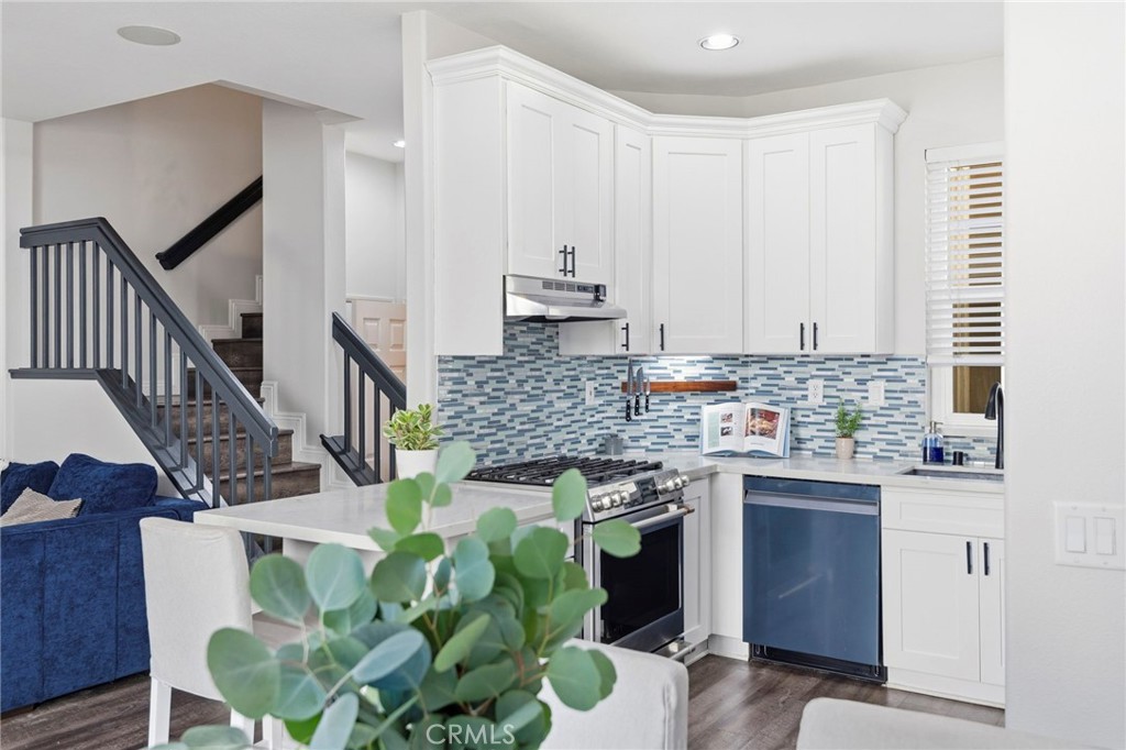 The open kitchen showcases quartz countertops, upgraded cabinetry, stainless steel appliances, and a thoughtfully select - 181 SeaCountry, Rancho Santa Margarita CA 92688 - photo 1
