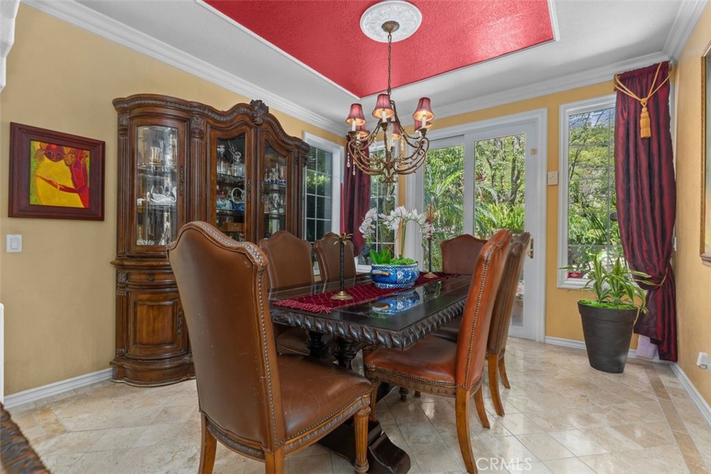 The formal dining room is anchored by a custom tray ceiling with medallion detail, elegant chandelier, and crown molding - 21792 Hermosa Lane, Rancho Santa Margarita CA 92679 - photo 10