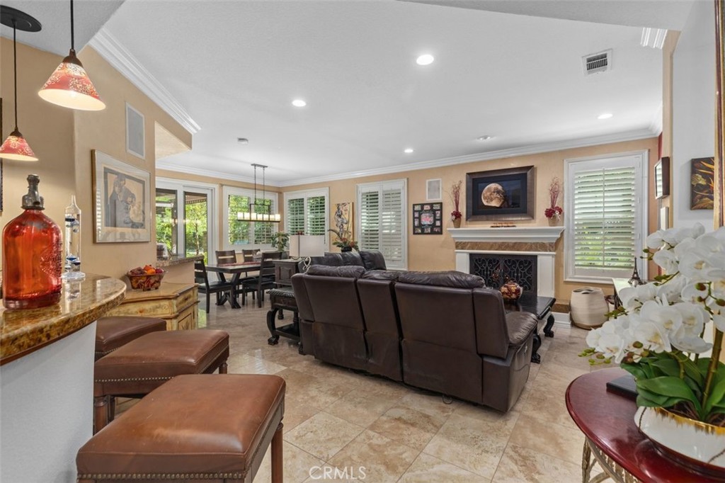 The spacious family room with fireplace flows openly to the casual dining area and granite topped bar with pendant light - 21792 Hermosa Lane, Rancho Santa Margarita CA 92679 - photo 18