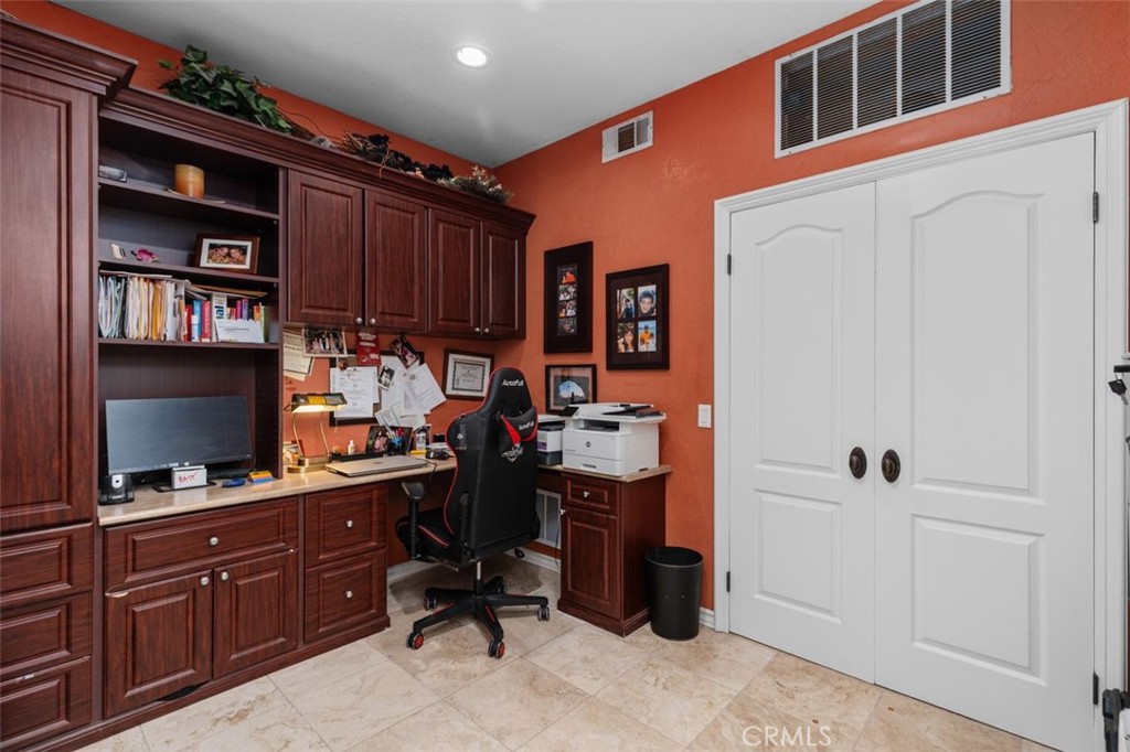 The main level library office features rich custom built in cabinetry with abundant shelving, desk space, and storage, p - 21792 Hermosa Lane, Rancho Santa Margarita CA 92679 - photo 20