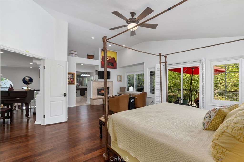The luxurious primary suite offers warm hardwood floors, plantation shutters, a private balcony overlooking the lush slo - 21792 Hermosa Lane, Rancho Santa Margarita CA 92679 - photo 25