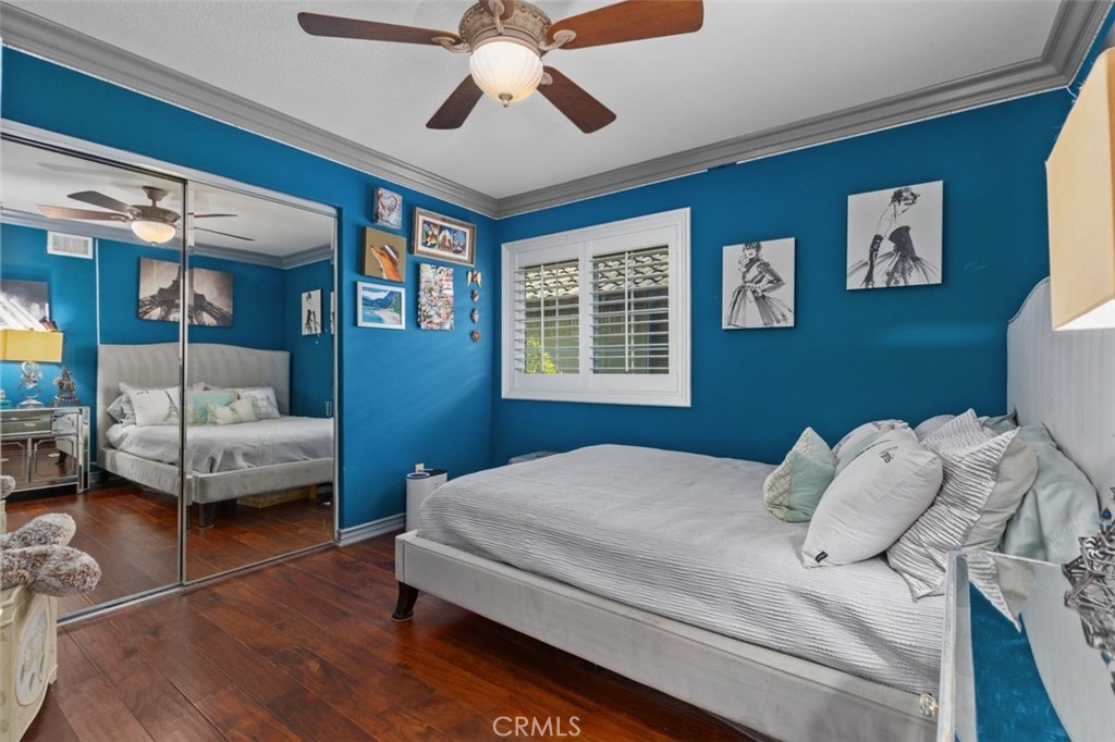 This generously sized upper level bedroom features rich hardwood floors, crown molding, a ceiling fan, plantation shutte - 21792 Hermosa Lane, Rancho Santa Margarita CA 92679 - photo 32