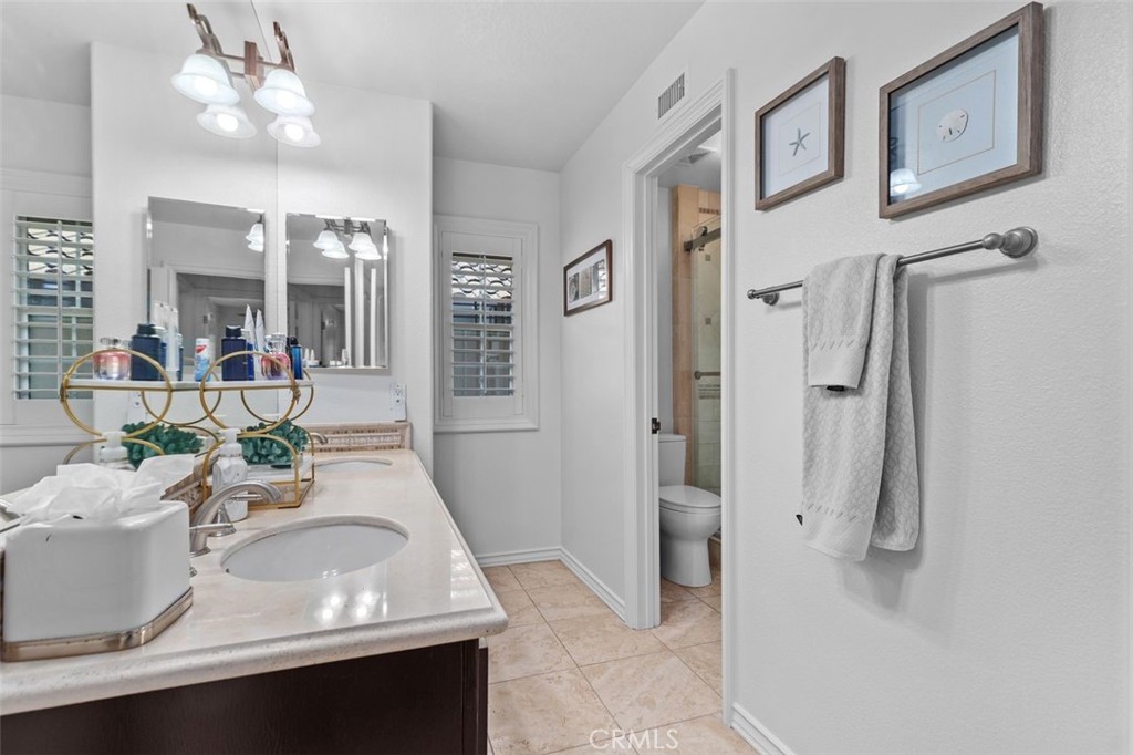 The Jack and Jill bathroom also features travertine tile flooring, and a private water closet with step in travertine sh - 21792 Hermosa Lane, Rancho Santa Margarita CA 92679 - photo 35