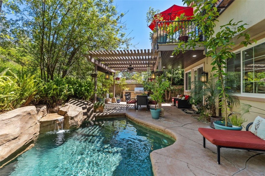This stunning backyard view showcases the sparkling pool with custom rock waterfall, the covered pergola lanai with ceil - 21792 Hermosa Lane, Rancho Santa Margarita CA 92679 - photo 38