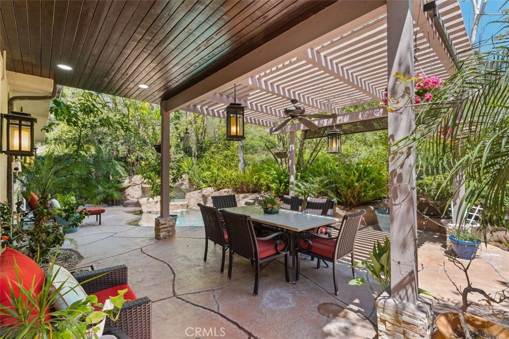 The covered poolside lanai features a pergola with ceiling fan, pendant lantern lighting, and a generous dining and loun - 21792 Hermosa Lane, Rancho Santa Margarita CA 92679 - photo 40