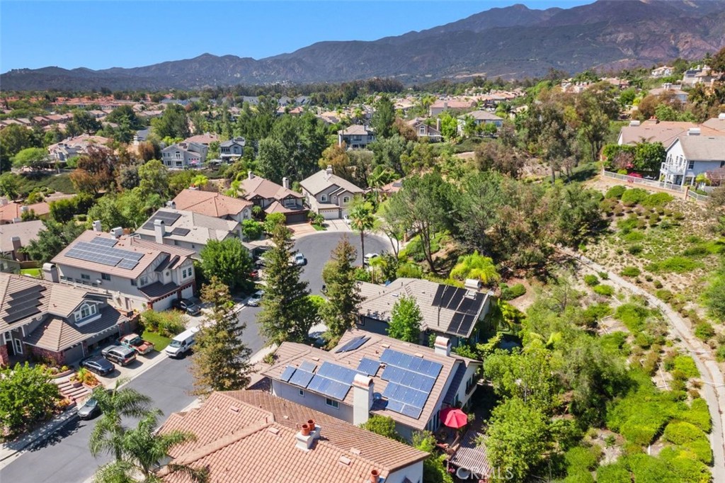 This impressive aerial view showcases the home's solar panels, tile roof, and private setting nestled among lush mature - 21792 Hermosa Lane, Rancho Santa Margarita CA 92679 - photo 47