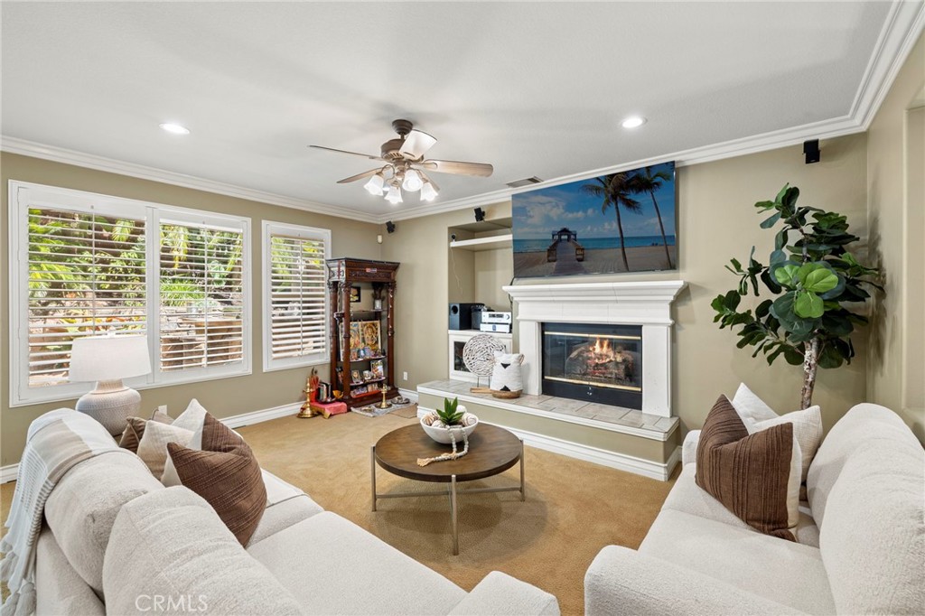 The family room features a fireplace, built-in shelving, and ceiling fan. - 30 Acanthus, Rancho Santa Margarita CA 92688 - photo 14