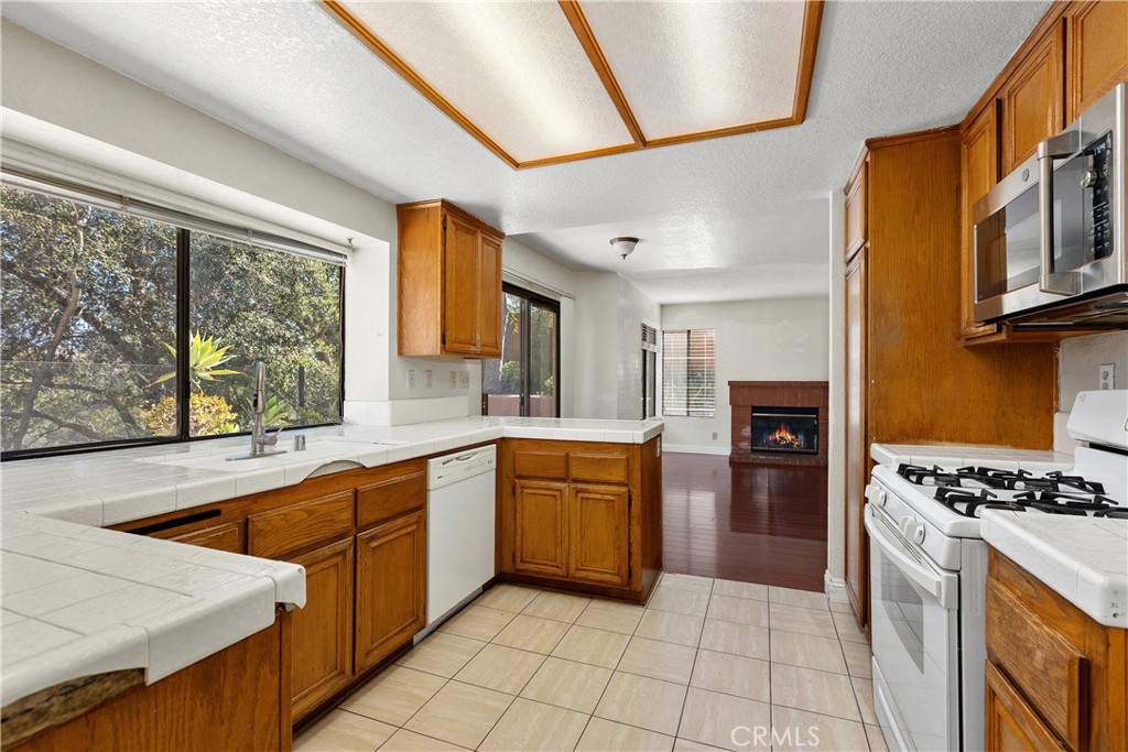 Kitchen from dining area - simulated fire in fireplace. - 30 San Bonifacio, Rancho Santa Margarita CA 92688 - photo 10