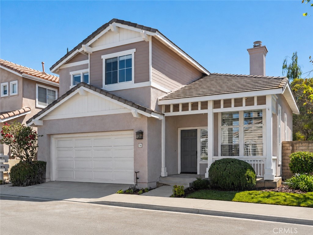 Exterior: Two-story home with an attached two-car garage, covered entry, contrasting exterior finishes, and neatly maint - 56 Acorn Ridge, Rancho Santa Margarita CA 92688 - photo 1