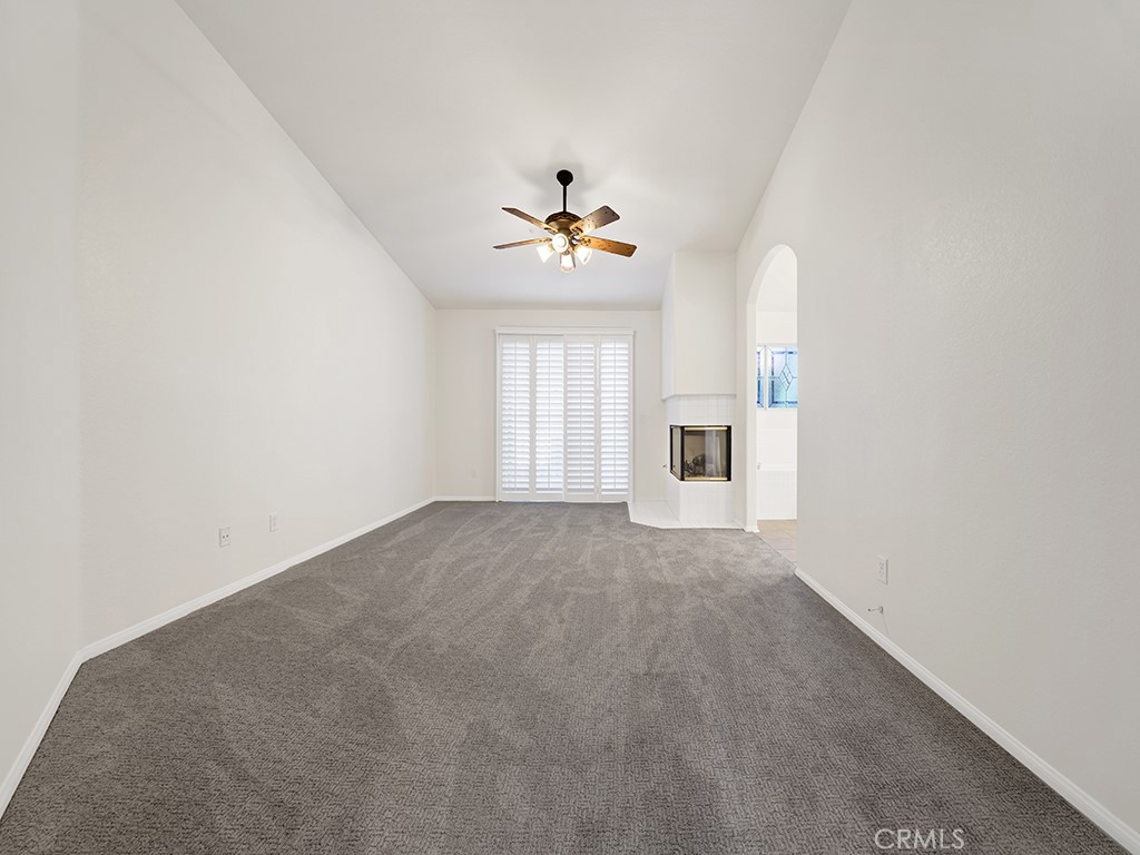 The primary bedroom has vaulted ceilings, a spacious walk in closet, a ceiling fan, a balcony and a fireplace. - 1031 Via Presa, San Clemente CA 92672 - photo 15